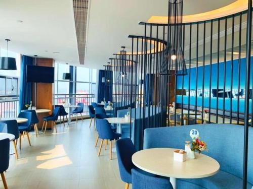 a dining room with blue chairs and tables and tablesktop at Jinjiang Inn is Qingdao Huangdao Dongjiakou Hotel in Poli
