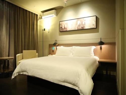 een groot wit bed in een hotelkamer bij JinJiang Inn WenZhouNan Railway Station Xinqiao in Wenzhou