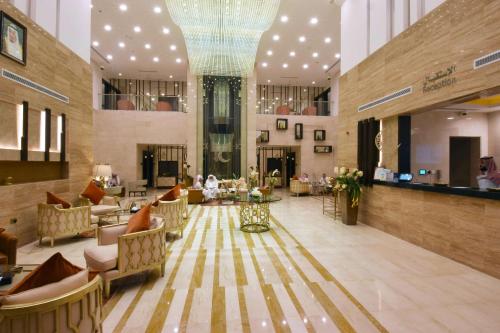 a lobby with a chandelier and tables and chairs at Best Plus Aurora Hotel in Riyadh