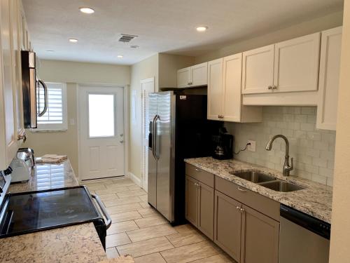 a kitchen with white cabinets and a stainless steel refrigerator at Island House Beach Resort 12S in Point O'Rocks