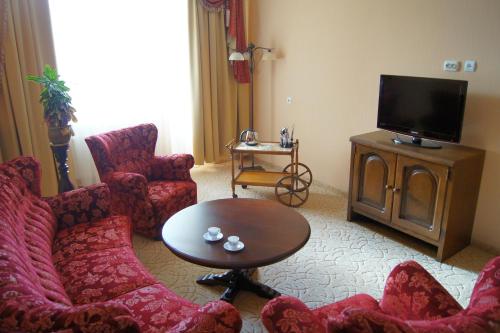 a living room with red chairs and a television at Erney Laz Hotel in Shaian