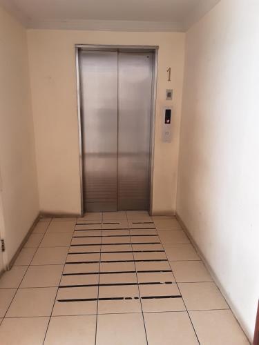 an empty hallway with a metal door in a building at MaranathaAparthotel in Talcahuano
