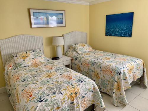 Duas camas sentadas uma ao lado da outra num quarto em Island House Beach Resort 36 em Point O'Rocks