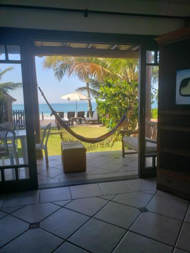 a porch with a hammock and a view of the beach at Pousada Pedra da Gaivota in Bombinhas