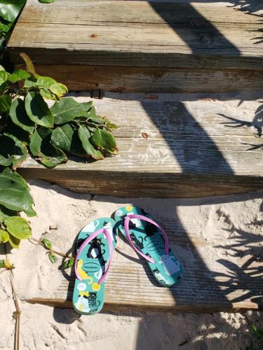 a childs sandals sitting on a wooden staircase at Pousada Pedra da Gaivota in Bombinhas