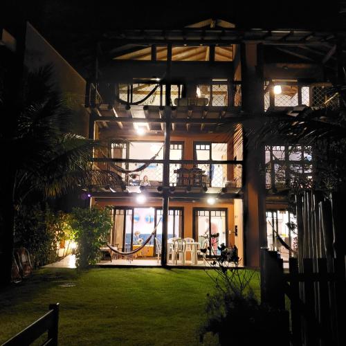 a house with large windows and a yard at night at Pousada Pedra da Gaivota in Bombinhas