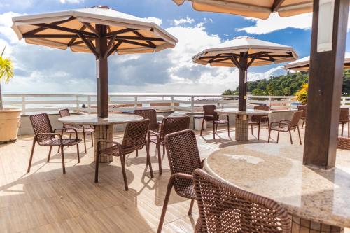 a patio with tables and chairs and umbrellas at Flat Pipa's Bay in Pipa