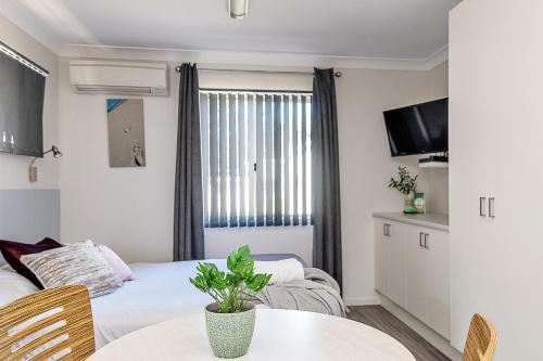 a room with two beds and a table and a tv at Holiday Haven Burrill Lake in Burrill Lake