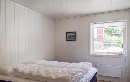 Schlafzimmer mit einem Bett und einem Fenster in der Unterkunft Beautiful Home In Tvedestrand With Ethernet Internet in Tvedestrand
