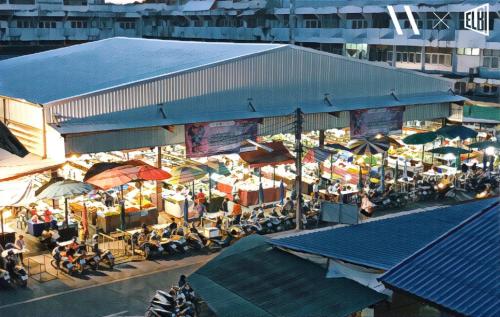 an overhead view of a market with tables and umbrellas at บ้านในกาด-ที่พักน่าน โรงแรมน่าน เที่ยวน่าน in Nan
