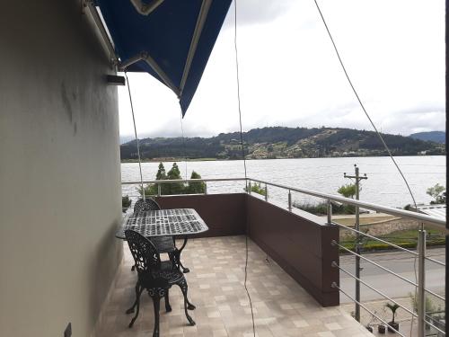 a balcony with a table and a view of the water at Pontevedra Hotel Boutique in Paipa
