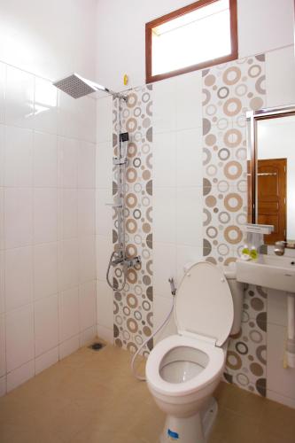 a bathroom with a toilet and a sink at Banua Raya Homestay in Yogyakarta