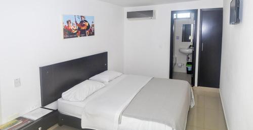 a bedroom with a large bed with white sheets at Hotel Las Margaritas Alojamientos in Barranquilla