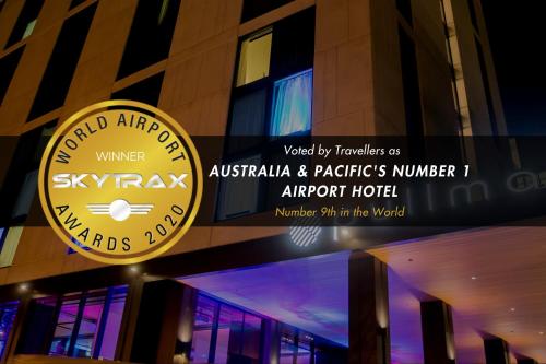 a building with two signs on the side of it at Pullman Sydney Airport in Sydney