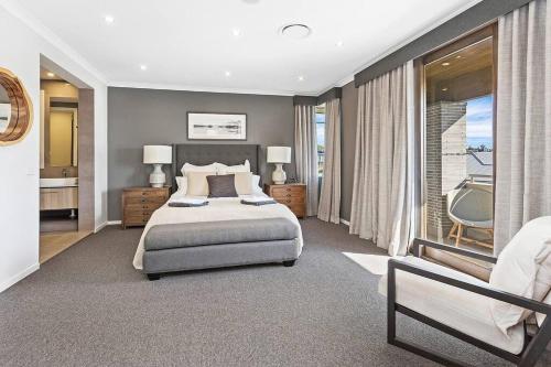 ein Schlafzimmer mit einem großen Bett und einem Balkon in der Unterkunft Luxury Brand New Home in Shellharbour