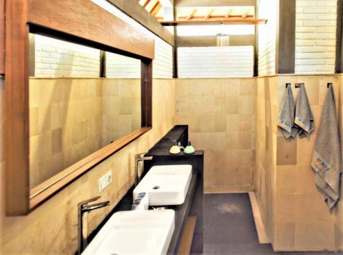 a bathroom with two sinks and a mirror at Hi Blue Bali Melasti Resort in Karangasem