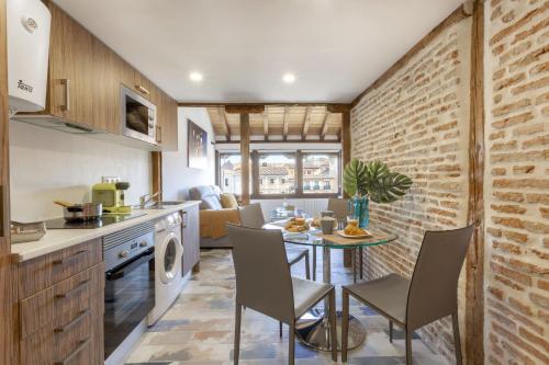 cocina y comedor con mesa y sillas en Hotel El Bedel en Alcalá de Henares