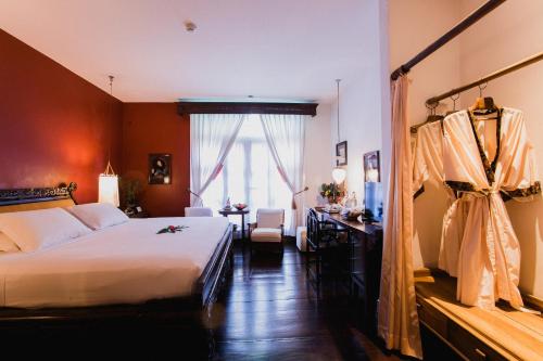 a hotel room with a bed and a desk and window at Hotel Tugu Malang - CHSE Certified in Malang