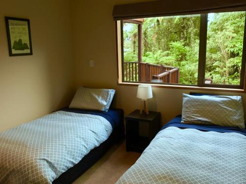 弗朗茲約瑟夫的住宿－The Ferns Hideaway，一间卧室设有两张床,窗户设有甲板。