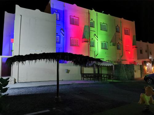 a building with colorful lights on it at night at Salassel Al Jabal Al Akhdar Guesthouse in Al ‘Aqar