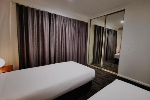 a hotel room with a bed and a large window at Littomore Suites Bathurst in Bathurst