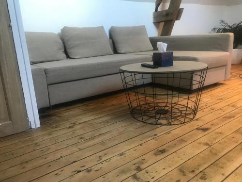 a living room with a couch and a table at Le petit manoir d'Hebuterne in Hébuterne