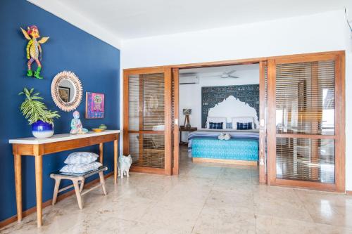 a room with a bedroom with a blue wall at Villa GMB Beach house in Uluwatu