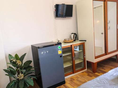 a small refrigerator in a room with a tv at Pranot Apartment & Spa in Nonthaburi