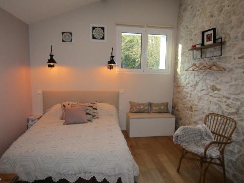 a bedroom with a bed and a stone wall at ferme gribeshaoutes in Préchacq