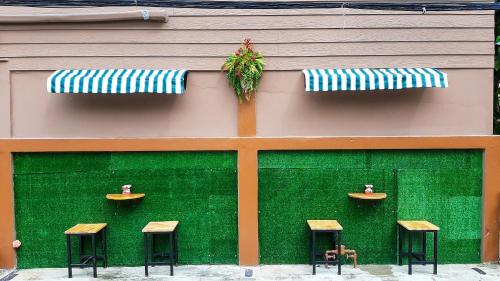 a building with four stools on the side of it at Pranot Apartment & Spa in Nonthaburi