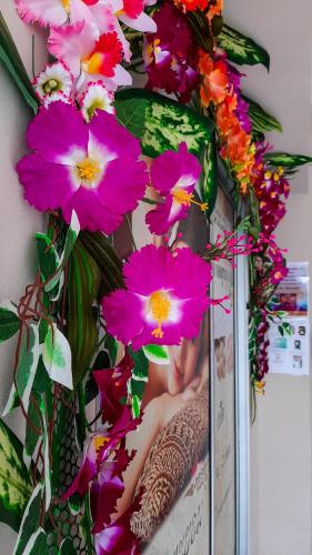 a wreath of pink flowers on a wall at Pranot Apartment & Spa in Nonthaburi