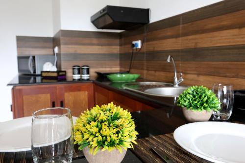 Iddamal Apartments في جبل لافينيا: مطبخ مع طاولة مع أكواب من المياه والزهور