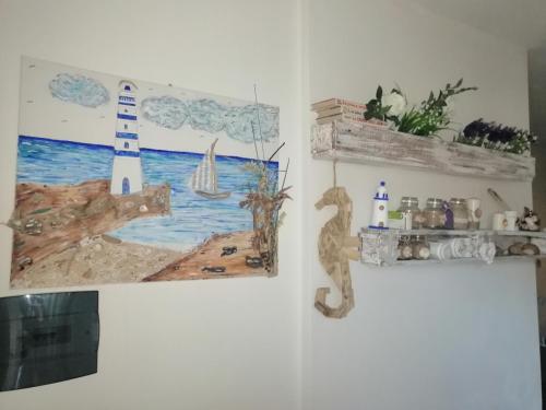 ein Zimmer mit einem Gemälde eines Leuchtturms an der Wand in der Unterkunft Cavalluccio Marino in Castelsardo