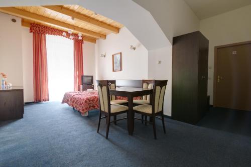 クリニツァ・ズドルイにあるApartamenty Renesansのテーブル、椅子、ベッドが備わる客室です。