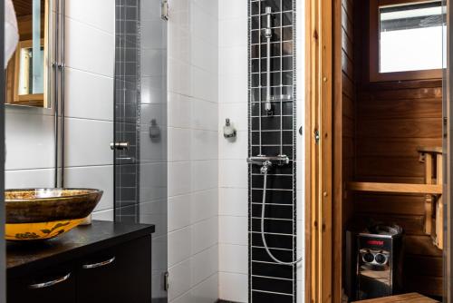 een badkamer met een wastafel en een glazen douche bij Hotel Rantakalla in Kalajoki