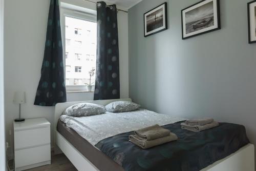 グダニスクにあるTricity Apartments - Gdansk, Jana Pawla IIのベッドルーム1室(ベッド1台、タオル2枚付)
