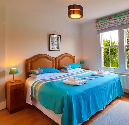 - une chambre dotée d'un grand lit avec des draps bleus dans l'établissement Muswell Hill B&B, à Londres