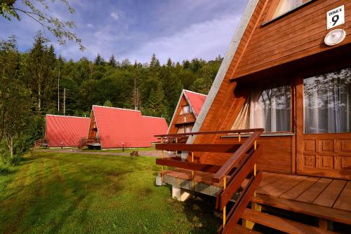 eine Gruppe von Häusern mit roten Dächern auf einem Feld in der Unterkunft Perełka Bieszczady Domki in Cisna