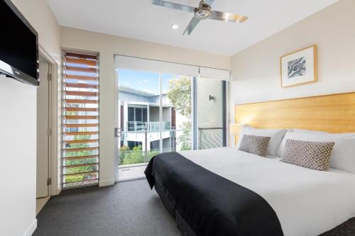 ein Schlafzimmer mit einem großen Bett und einem großen Fenster in der Unterkunft RACV Noosa Resort in Noosa Heads