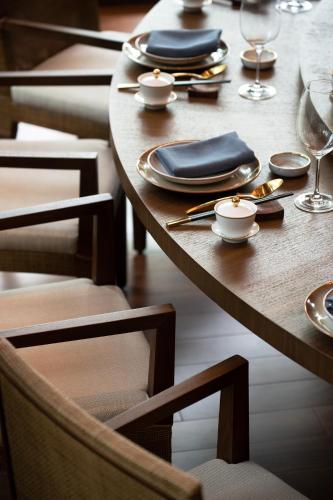 a wooden table with plates and napkins on it at New World Qingyuan Hotel -formerly KHOS QINGYUAN in Qingyuan