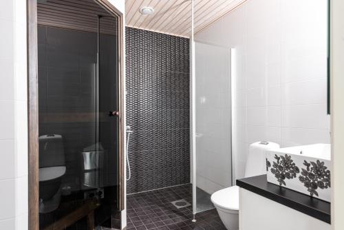 a bathroom with a toilet and a glass shower at Rantakallan Hongisto huoneistot in Kalajoki