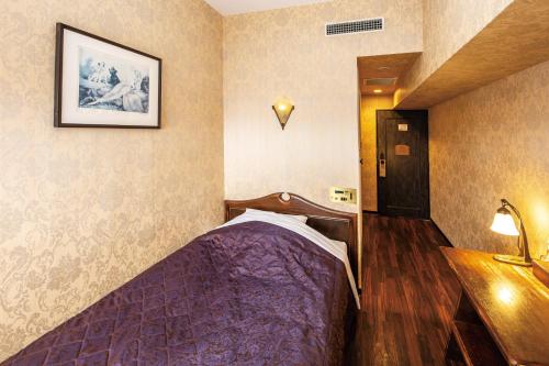 1 dormitorio con 1 cama de color púrpura en una habitación en Okazaki Ohwa Hotel, en Okazaki