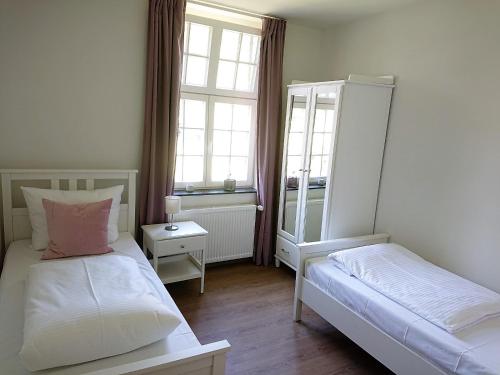 a small bedroom with two beds and a mirror at Ferienwohnungen Georgenbruch in Everswinkel