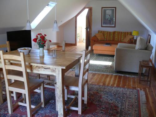 a dining room and living room with a table and chairs at The Motor House in Ledbury