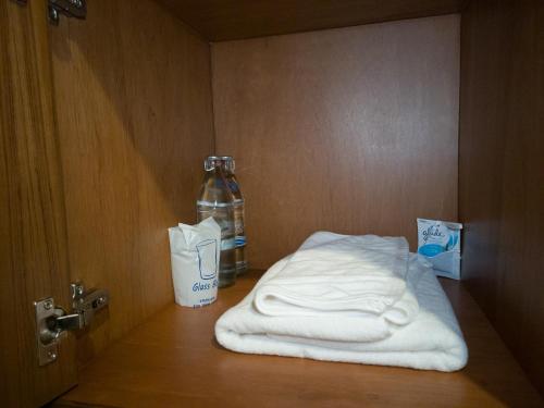 a pair of towels and a bottle of water in a room at Psych Hostel in Chiang Mai
