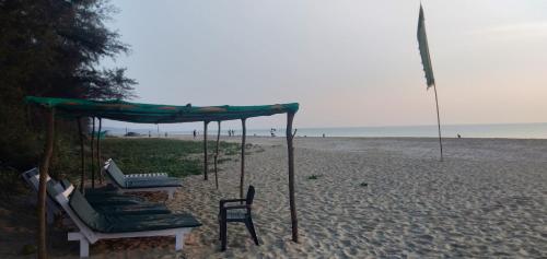 a group of chairs and a canopy on the beach at OmBodhi Retreat in Kumta