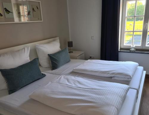 two white beds in a room with a window at Ferienwohnungen Georgenbruch in Everswinkel
