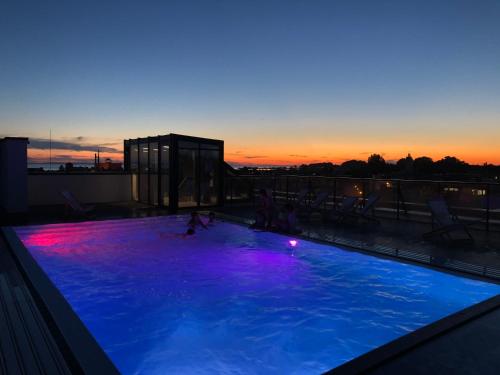 a large swimming pool with purple lights on top of a building at Natural Hel Apartamenty in Hel