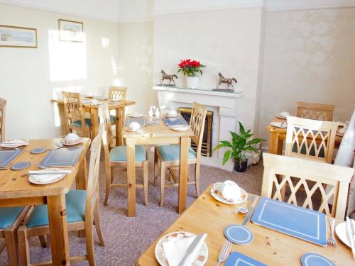 斯沃尼奇的住宿－Amberlea Guest House，用餐室配有木桌和椅子