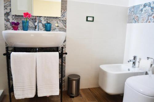 un bagno bianco con lavandino e WC di B&B Vivere San Vito Lo Capo a San Vito lo Capo